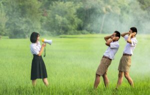 Woman Creating Loud Noise with a Megaphone - The Best Hearing Aids for Seniors