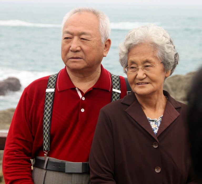 An elderly couple taking a photograph at the beach - Disposable Incontinence Underwear