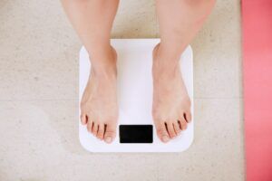 Woman standing ion a scale - Incontinence in Seniors