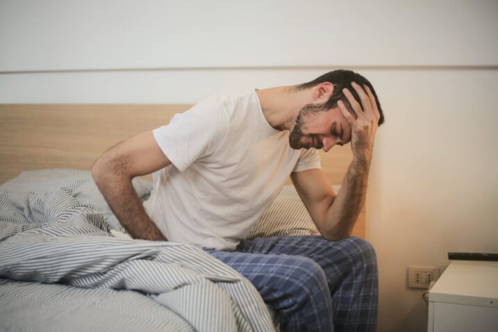 Man sitting on one side of the bed - Why Proper Hydration is Important Especially in Hot Weather
