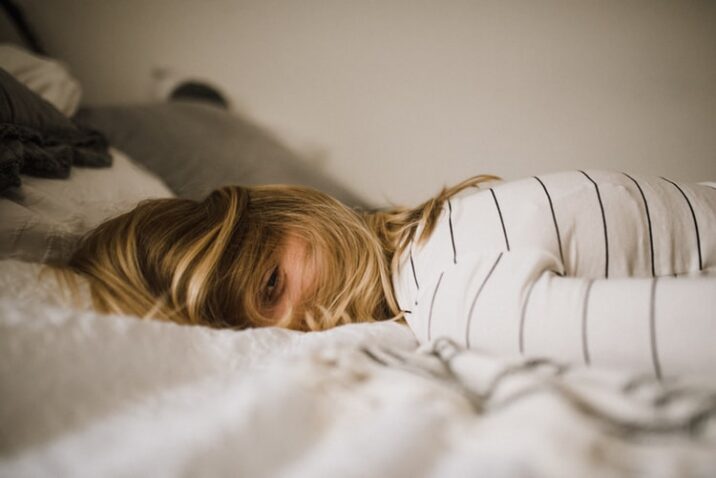 Woman sleeping face down on a bed