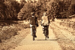 2 Seniors Bicycling down a lonely road - Healthy Aging Tips for Seniors