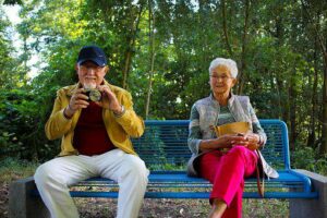 Elderly man and woman sitting on a bench in the park