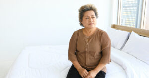 An-elderly-woman-sitting-alone-on-the-bed