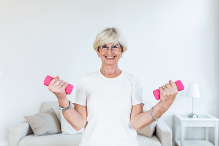 Senior exercising with two pink dumbbells - Causes of Falls in Seniors