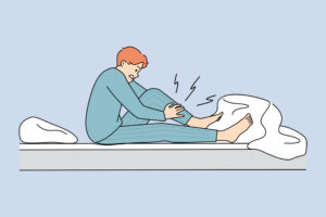 Man wakes up at night suffering from leg cramp massaging the leg