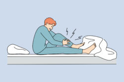 Man wakes up at night suffering from leg cramp massaging the leg