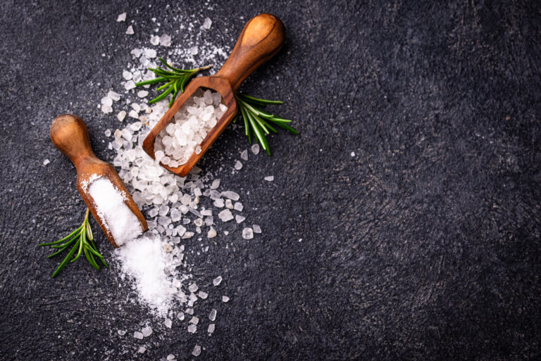 Natural sea salt crystals on dark background - Salt vs Sugar