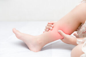 Leg cramp in a senior on a bed - Causes of Leg Cramps at Night
