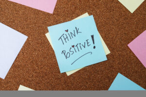 Stay positive sticky note on a corkboard - Positive Thinking and Health