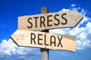 stress-relax-wooden-signpost-with-two-arrows-sky-with-clouds-in-background - How Does Stress Affect Aging