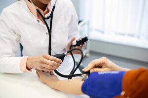 Unlock 5 Recommended Health Screenings for Adults 3 Doctor-measuring-blood-pressure-of-a-woman - Unlock 5 Recommended Health Screenings for Adults