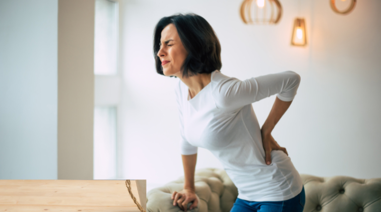 Womain experiencing lower back pain - 8 Best Back Braces for Lower Back Pain Relief