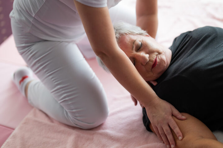 Concerned-caregiver-kneeling-beside-an-elderly-woman-who-has-fallen-in-the-living-room-lifting-her-head-up-slowly- What to Do After a Senior Falls