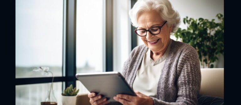 Elderly lady with glasses smiling using a tablet at home browsing internet or watching videos - How to Use Technology for Aging in Place